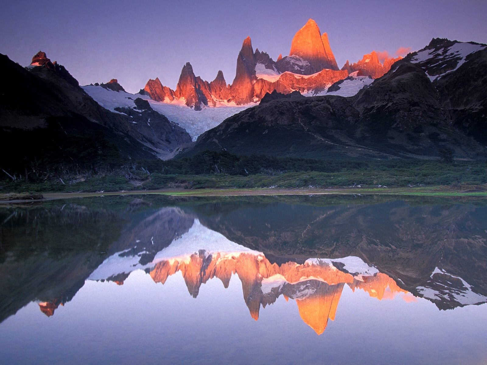 Monte Fitz Roy nevado ao amanhecer, refletido na lagoa, em El Chaltén, Patagônia argentina